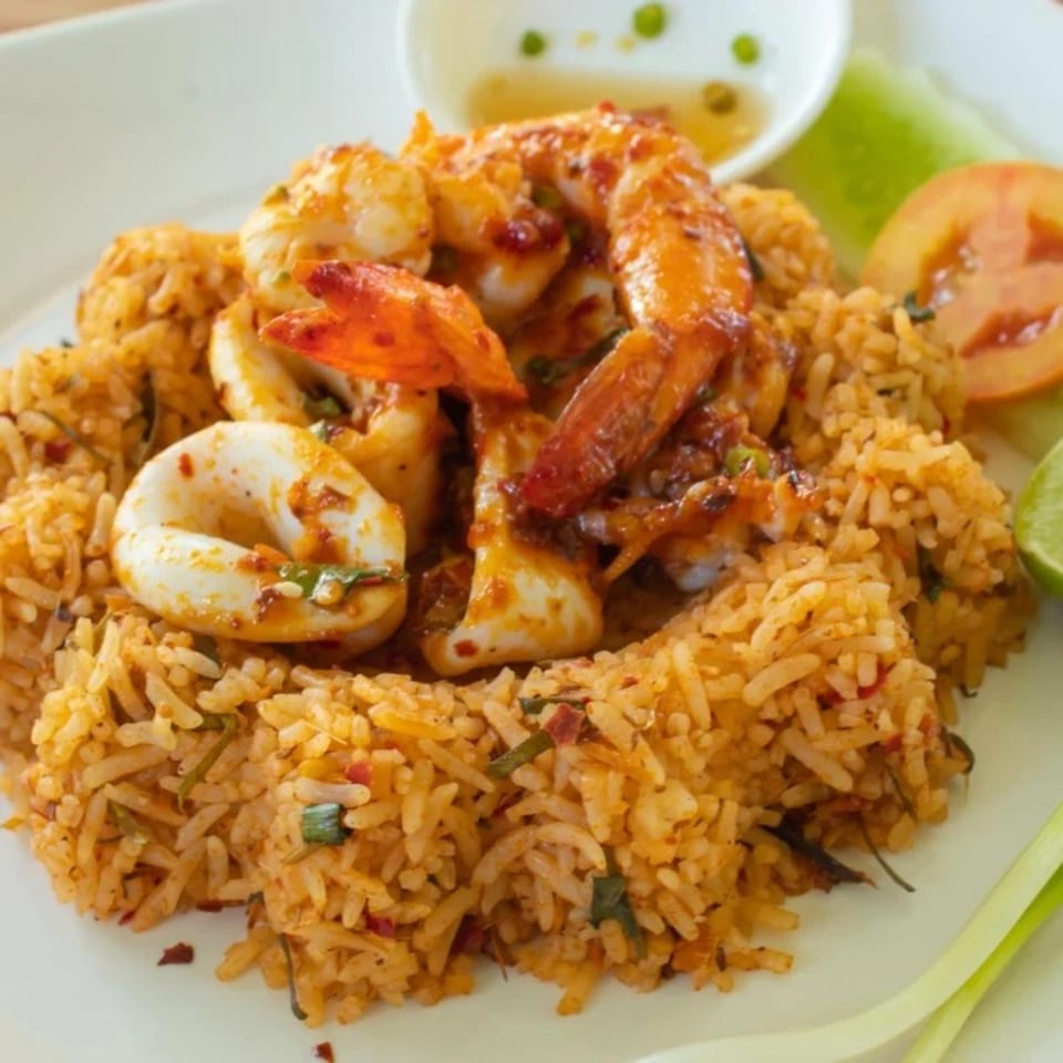 Thai Del Mar's spicy fried rice with shrimp and calamari, garnished with lime and tomato.